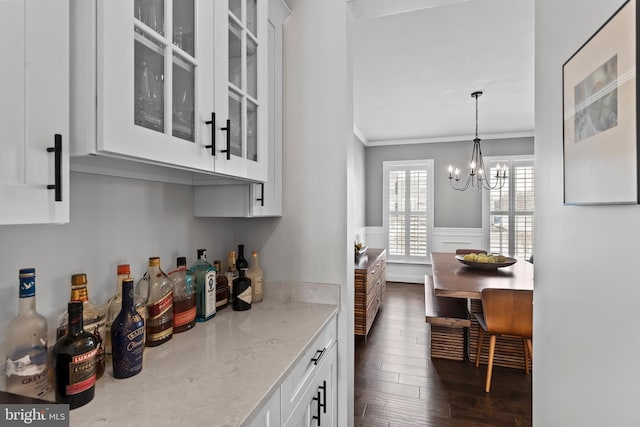 1335 Ashton Rd, Mechanicsburg, PA 17055 - bar featuring a notable chandelier, crown molding, pendant lighting, dark wood-type flooring, and a wainscoted wall