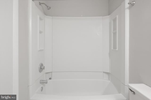 bathroom featuring shower / bathing tub combination and toilet