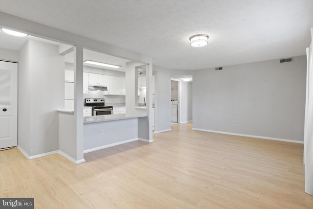 unfurnished living room with light hardwood / wood-style floors and a textured ceiling