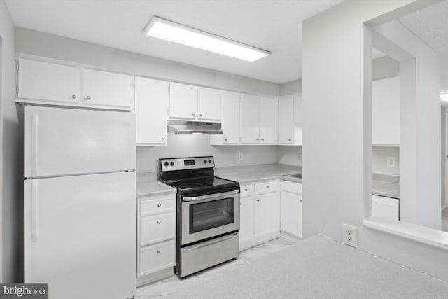 kitchen with stainless steel electric range, white cabinetry, and white fridge