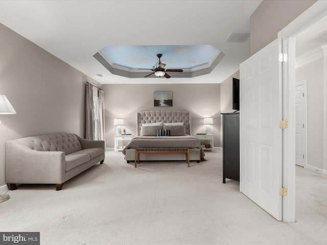 bedroom with ceiling fan, light carpet, visible vents, baseboards, and a raised ceiling