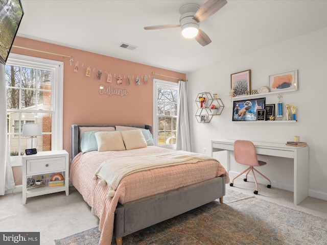 carpeted bedroom with baseboards, visible vents, and a ceiling fan