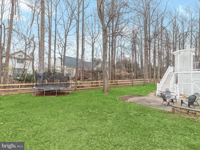 view of yard featuring a patio, stairway, a trampoline, and a fenced backyard