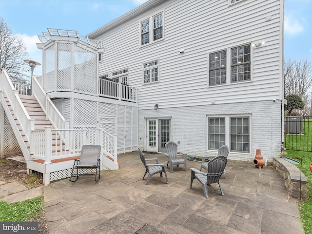 rear view of house with a patio area, stairs, and a fire pit