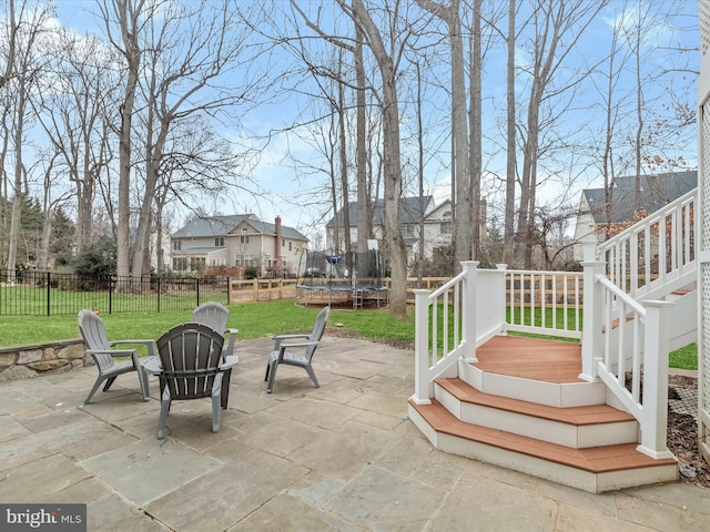 view of patio / terrace with a trampoline, a residential view, and fence