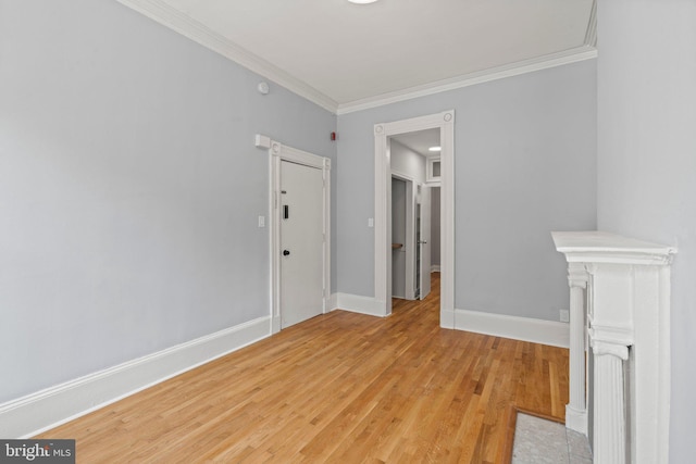 empty room with crown molding and light hardwood / wood-style floors