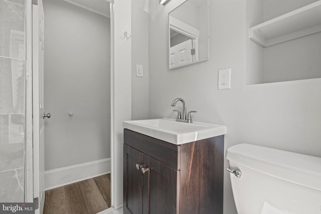 bathroom with toilet, vanity, and wood-type flooring