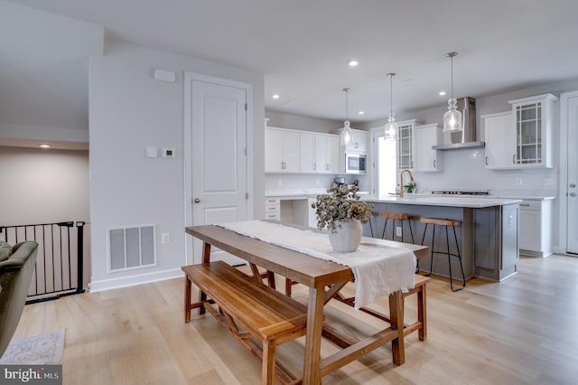 dining room featuring sink and light hardwood / wood-style flooring