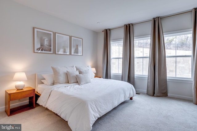 bedroom with multiple windows and light carpet