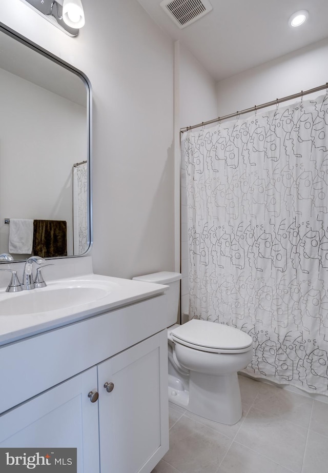 bathroom featuring vanity, tile patterned floors, and toilet