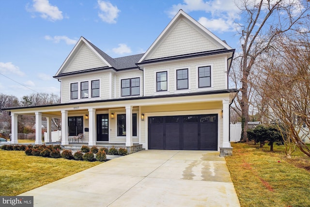 view of front of property featuring a garage, a front lawn, and covered porch