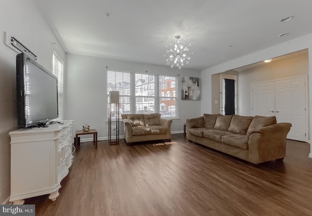 living room featuring an inviting chandelier, plenty of natural light, and dark hardwood / wood-style flooring