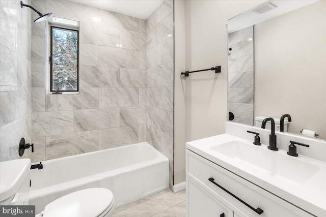 full bathroom featuring toilet, tiled shower / bath, and vanity