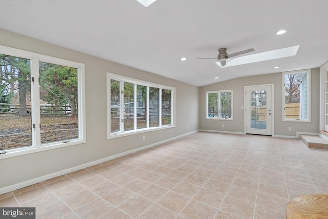 interior space featuring ceiling fan, a wealth of natural light, lofted ceiling with skylight, and light tile patterned flooring