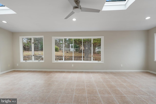 tiled spare room with ceiling fan and a skylight