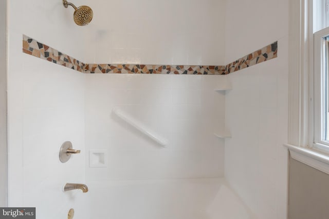 interior details featuring tiled shower / bath combo