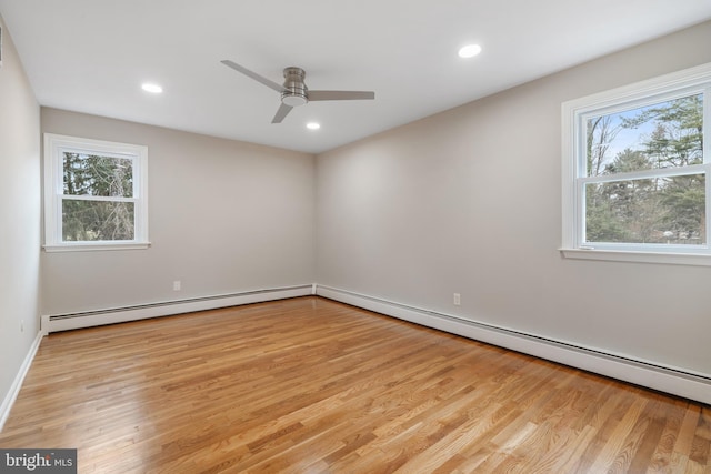 empty room featuring ceiling fan, light hardwood / wood-style floors, and a baseboard radiator