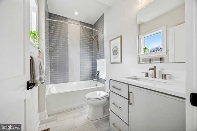 full bathroom with toilet, vanity, and tiled shower / bath