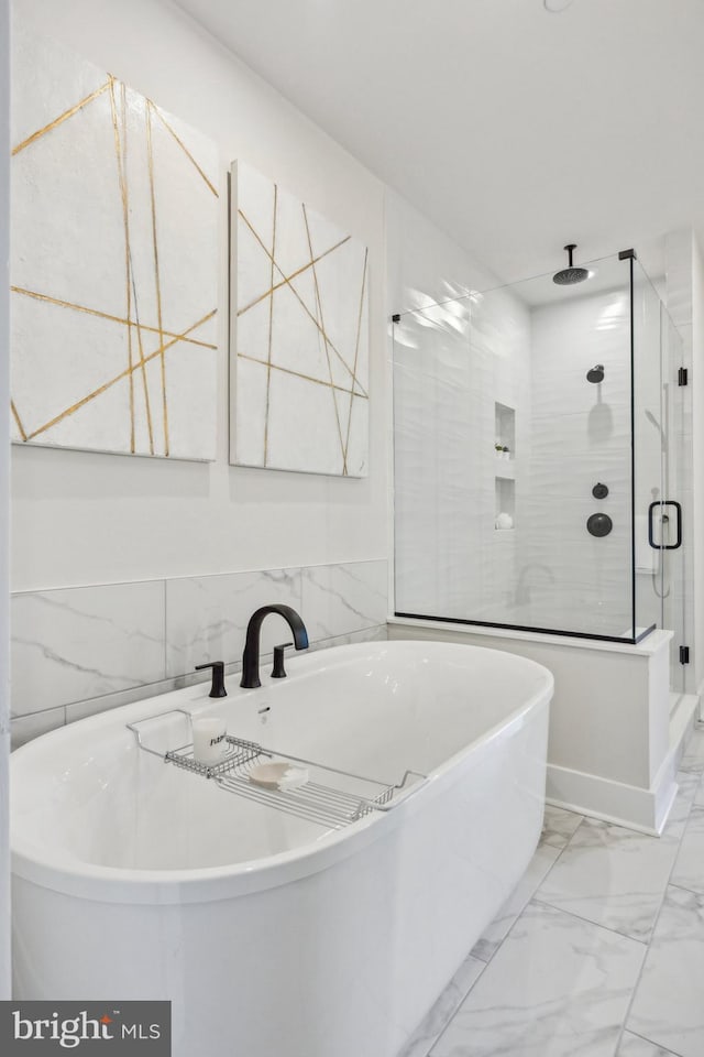 bathroom with tile walls and independent shower and bath