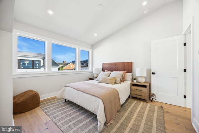 bedroom featuring light hardwood / wood-style floors and lofted ceiling