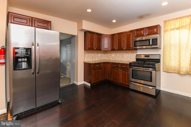 kitchen with tasteful backsplash, appliances with stainless steel finishes, light stone countertops, and dark wood-type flooring