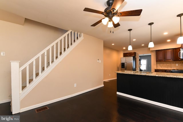 kitchen featuring sink, tasteful backsplash, decorative light fixtures, stainless steel appliances, and light stone countertops