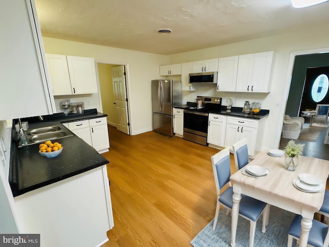 kitchen featuring white cabinets, appliances with stainless steel finishes, and sink