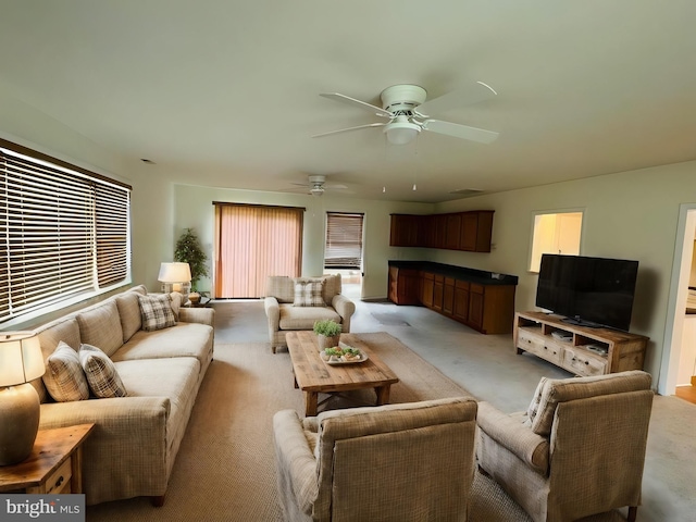 carpeted living room with ceiling fan