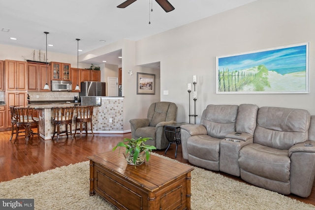 living room featuring ceiling fan and dark wood-type flooring