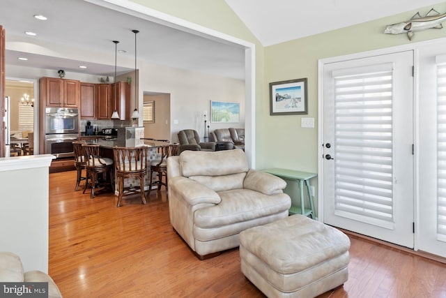 living room featuring vaulted ceiling and light hardwood / wood-style flooring