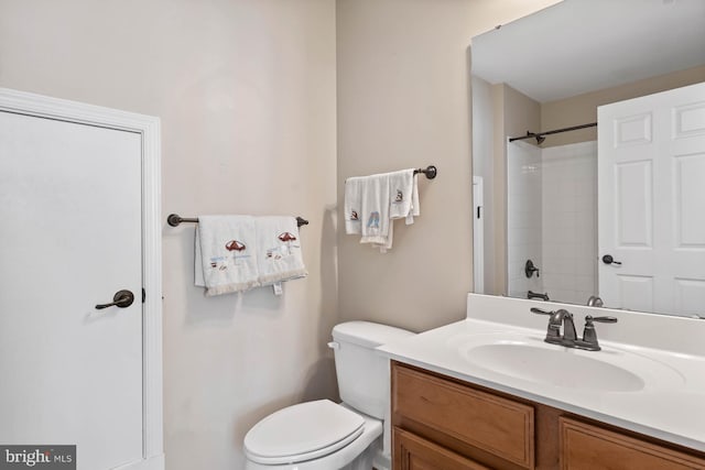 bathroom featuring toilet, vanity, and walk in shower