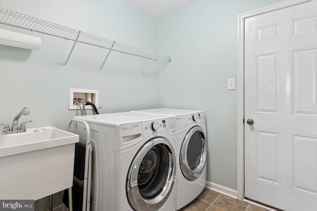 laundry room with dark tile patterned floors, sink, and separate washer and dryer