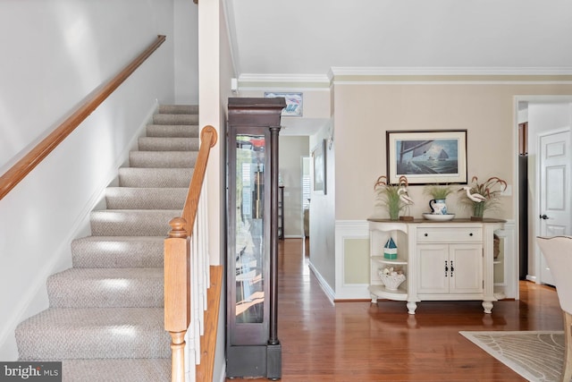 stairway featuring wood-type flooring and crown molding