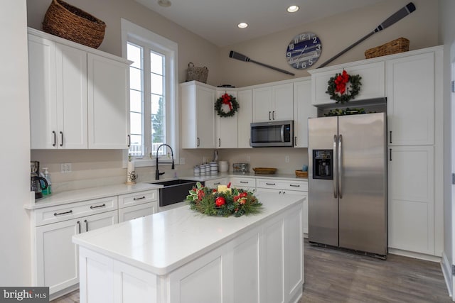 kitchen featuring sink, white cabinets, stainless steel appliances, and a kitchen island