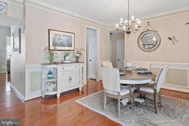 dining space with crown molding, a chandelier, and hardwood / wood-style floors