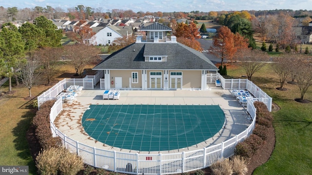 back of property with a covered pool and a patio