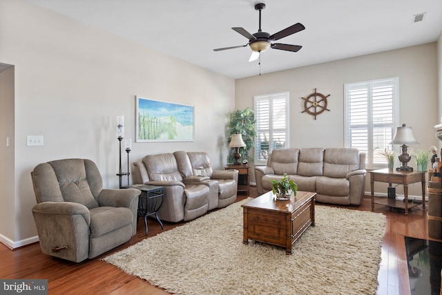 living room featuring ceiling fan and dark wood-type flooring