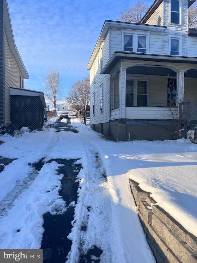 view of snowy exterior featuring a porch