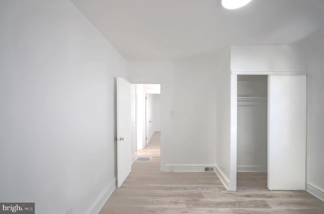 unfurnished bedroom featuring a closet and light hardwood / wood-style flooring