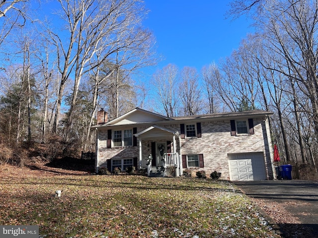 bi-level home with a garage and a front lawn