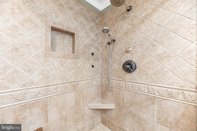 bathroom with ornamental molding and tiled shower