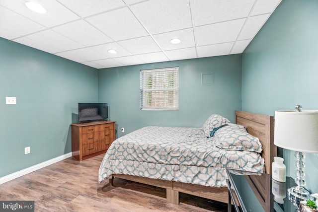 bedroom featuring hardwood / wood-style flooring and a paneled ceiling