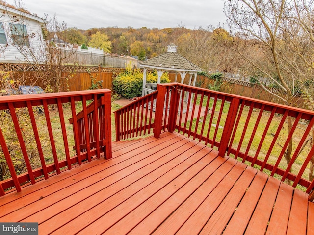 wooden terrace with a gazebo and a yard