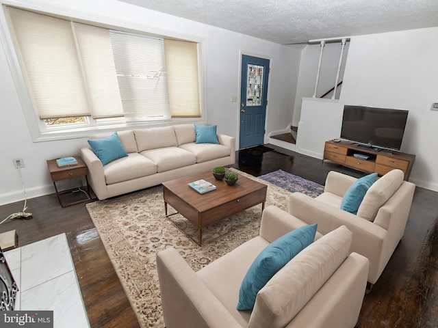 living room with a textured ceiling and dark hardwood / wood-style floors