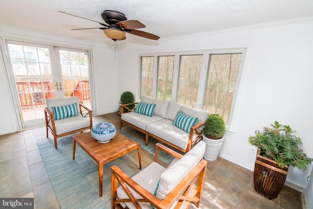 sunroom featuring ceiling fan and french doors