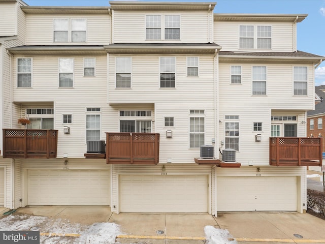 rear view of house featuring a garage and cooling unit