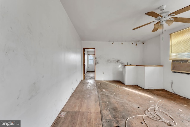 empty room featuring cooling unit, vaulted ceiling, and ceiling fan