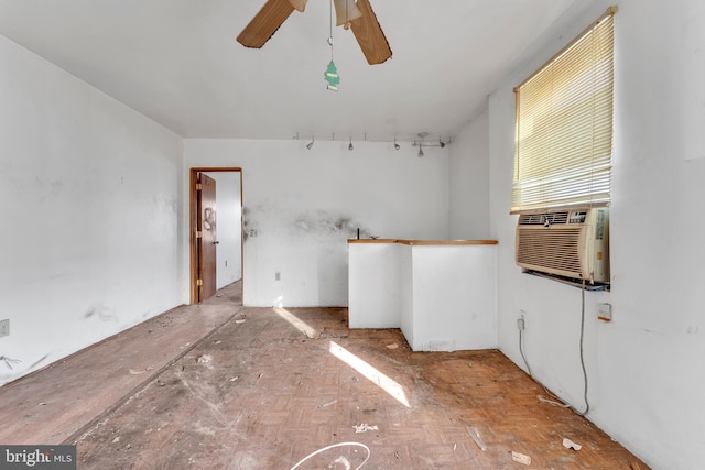 empty room featuring cooling unit and ceiling fan