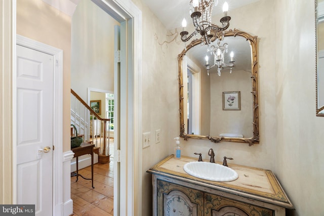 bathroom with an inviting chandelier, vanity, and hardwood / wood-style flooring