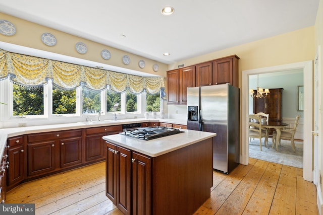 kitchen featuring sink, a chandelier, a center island, light hardwood / wood-style flooring, and appliances with stainless steel finishes